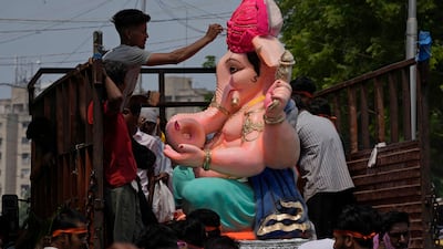 A man gives finishing touches to an idol of elephant-headed Hindu God Ganesha on a vehicle during Ganesh Chaturthi festival celebrations in Ahmedabad, India. AP Photo