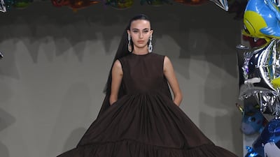 Amira Al Zuhair appears for Giambattista Valli in a high-low taffeta gown in burnt chocolate. Getty