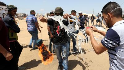 Palestinian demonstrators prepare to set a kite on fire. Ibraheem Abu Mustafa / Reuters