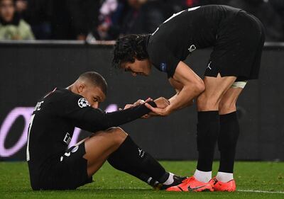 Paris Saint-Germain's Edinson Cavani, right, tries to cheer up teammate Kylian Mbappe at the end of the game. Franck Fife / AFP