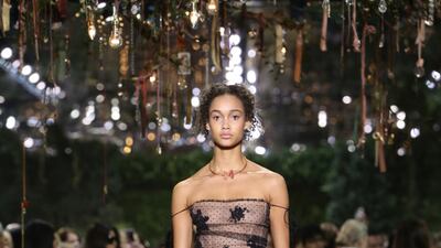 Maria Grazia Chiuri presented her first haute couture collection for Christian Dior in the gardens of the Musee Rodin, and centred her collection around the brand’s iconic Bar jacket. This saw literal jackets and coats in varying lengths give way to a more pared down approach that focused entirely on the cinched-in waist and classic 1950s silhouette. This came to life in an embroidered tulle dress made from black net and decorated with stylised flowers, laid over nude tulle. The multiple layers of gossamer tulle created volume and airiness, while thin ties, carelessly slipped off shoulders, added to the simplicity of the overall look. Courtesy of Christian Dior