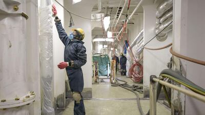 A worker prepares a hallway for painting below the decks of an under-construction Maersk triple-E class container ship. Ed Jones / AFP