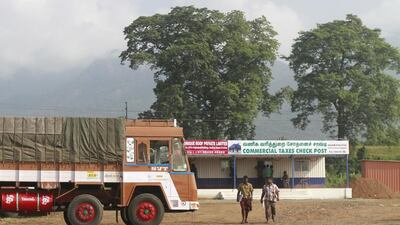 Lorry drivers walk out of a commercial taxes post after getting clearance to cross a Chavadi checkpoint with their goods in the southern Indian state of Tamil Nadu, India. Sivaram V / Reuters