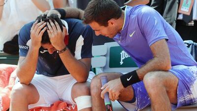 Juan Martin Del Potro, right, consoles Nicolas Almagro after the Spaniard was forced to retire from their French Open second round match due to injury. Thomas Samson / AFP