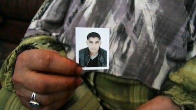 Mabrouka Hillal holds a picture of her son, Walid, thought to have been killed while fighting in Syria.