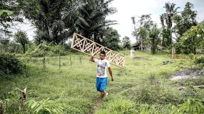A worker prepares pieces of wood for a prefabricated wooden house. Manufacturers are now exporting the prefabricated Woloan houses to Argentina, Norway, Poland, Japan, South Korea, the Philippines and the United States. Putu Sayoga / Getty Images