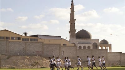 Palestinian players in Gaza warm up as they run laps around their club's field in the early evening in Gaza City. (Photo by Heidi Levine for The National).