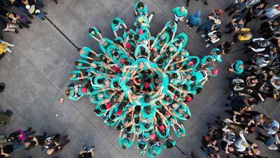 Members of the "Castellers de Villafranca" Human Tower team form a "castell" during an exhibition to celebrate the 75th anniversary of their foundation at the Zocalo square in Mexico City on November 21, 2023. (Photo by Rodrigo Oropeza / AFP)