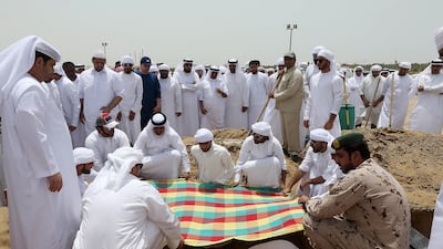 Friends and family members attend the burial of Khaled Qai at the Al Qusais Cemetery in Dubai. Pawan Singh / The National