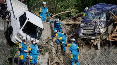 Rescuers search for missing people at a mudslide site in Kumano, Hiroshima. Kyodo News / AP