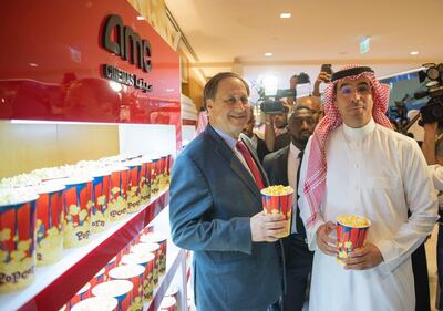 Adam Aron, CEO of AMC Entertainment, and Saudi Minister of Culture and Information Awwad Alawwad grab two popcorn buckets at the inauguration of the Kingdom's first public cinema at King Abdullah Financial District. Saudi ministry of culture / EPA