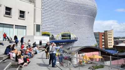 People sit outside the Bullring shopping centre in Birmingham, central England. Average property prices in the city are £202,162 with an average rental yield of 5.4 per cent. AFP