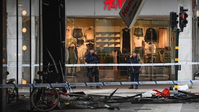 Police officers guard at the site where a man killed three after driving a van into a crowd in Stockholm on April 8, 2017(AFP)