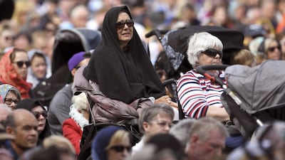 Members of the public look on during a gathering for congregational Friday prayers and two minutes of silence for victims of the twin mosque massacre at Hagley Park. AFP