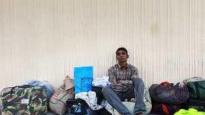 Musabbir Miah from Bangladesh sits with the belongings he and his flatmates could salvage from their building.