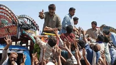 Flood victims struggle to receive food near a tent camp in Sukkur in Sindh province of Pakistan. Nadeem Khawer / EPA