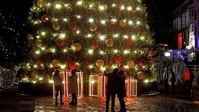 Lebanese stand near a Christmas tree in the coastal city of Byblos. AFP