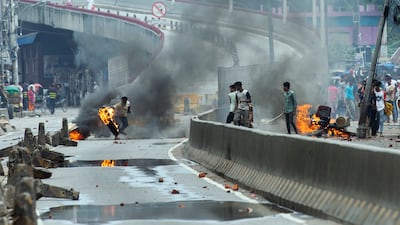 Burning tyres are hurled at police during demonstrations in Dhaka. AP