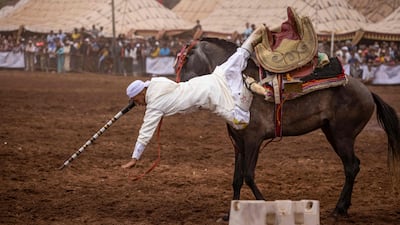 A Moroccan rider falls from his horse during his performance at the Moussem in Rabat.