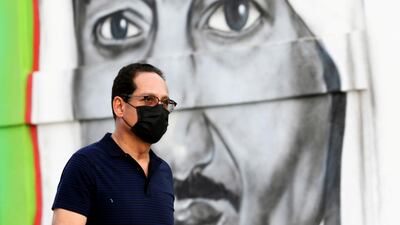 A man walks past a poster of Saudi Arabia's King Salman in Riyadh, where full lockdown has been imposed to prevent the spread of Covid-19 infections. Reuters