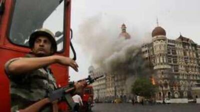 A soldier gestures as the Taj Mahal hotel burns during gun battles late last month between the Indian army and militants inside the hotel.