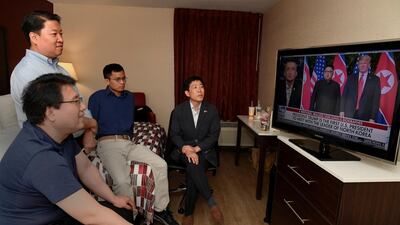 North Korean defectors Park Sang Hak and Justin Kim watch replays of US President Donald Trump's summit meeting in Singapore with North Korea leader Kim Jung Un on television, at a motel in Leesburg, Virginia. Also watching are South Korean human rights activists Do Hee Yun and Henry Song. Mike Theiler / Reuters