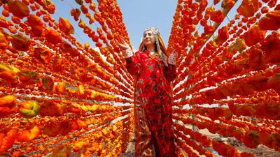 A woman arranges peppers for drying in the sun as seasonal workers process tomatoes after a harvest in Gaziantep, Turkey, last August. Getty Images