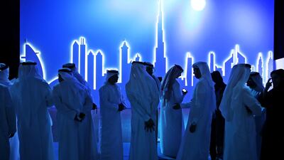 Emirati attendees wait in front of an image of the city's skyline in Dubai, United Arab Emirates, Wednesday, March 5, 2014. After years of chasing the biggest and the best, the fast-growing Mideast city of Dubai is turning to technology to help the little things in life run more smoothly. (AP Photo/Kamran Jebreili)