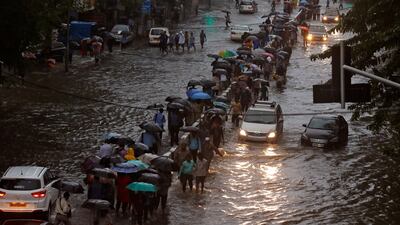 Commuters walk through water-logged roads after rains in Mumbai. Shailesh Andrade / Reuters