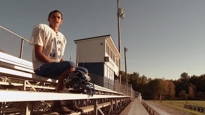 Cambridge Springs high school American football player Kris Silbaugh poses on the bleachers during an interview at practice in Cambridge Springs, Pa. Silbaugh, born without a left hand, is the teams starting wide receiver, punter and defensive back. Joshua Replogle / AP Photo