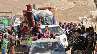 Lebanese security forces check identity and papers of Syrian refugees getting ready to cross into Syria from the eastern Lebanese border town of Arsal, Lebanon, on June 28, 2018. Stringer / AFP