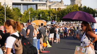Demonstrators coming from a rally stand nearby the Reichstag building, the seat of the German parliament, following a protest against coronavirus pandemic regulations in Berlin, Germany. EPA