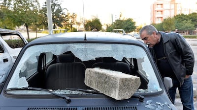 A man looks at a damaged car. EPA