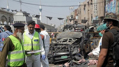Security officials and members of a bomb disposal team survey the site after the blast. Reuters