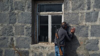 A man kisses the walls of his home before abandoning it as fear of Azeri persecution prompts him to leave his homeland in Karvachar, Nagorno-Karabakh. Getty Images
