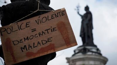 A placard which reads "violent police = sick democracy" hangs in Place de la Republique, Paris. Joel Saget / AFP