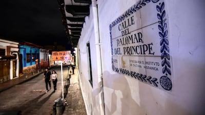 People walk at the historic district of La Candelaria, in Bogota at night. AFP