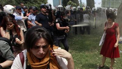 A Turkish riot policeman uses tear gas on Ceyda Sungur during a protest in Istanbul's Gezi Park on May 28, 2013. Osman Orsal / Reuters