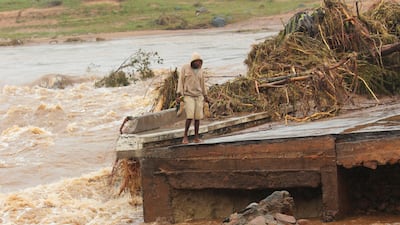 A man stands on the edge of a collapsed bridge in Chimanimani, about 600km southeast of Harare, Zimbabwe. AP Photo
