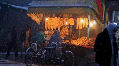 An Afghan woman buys bread from a street vendor during a snow storm in Kabul, Afghanistan. Massoud Hossaini / AP Photo