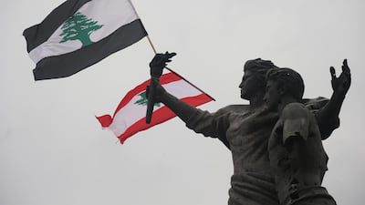 Two Lebanese flags in Martyrs' Square, in downtown Beirut near the port explosion, which has exacerbated the economic woes of the country. EPA