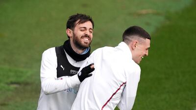 Manchester City's Bernardo Silva, left, and Phil Foden share a joke on the training pitch. PA.