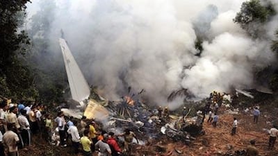 Civilians look on as Indian firefighters and rescue personnel gather around the site of an Air India plane that crashed in Mangalore, in the southern Indian state of Karnataka.