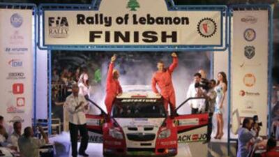 Roger Feghali, right, salutes spectators with his co-driver, Nabil Njeim, after winning Rally Lebanon yesterday.