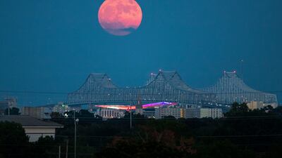 A blue supermoon rises behind the Crescent City Connection in New Orleans. AP