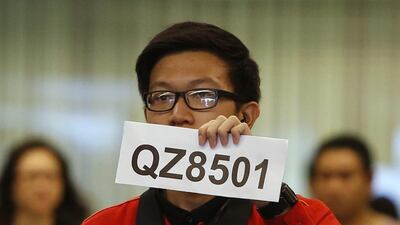 A Changi Airport staff holds up a sign to direct possible next-of-kins of passengers of AirAsia flight QZ 8501 from Indonesian city of Surabaya to Singapore. Edgar Su / Reuters