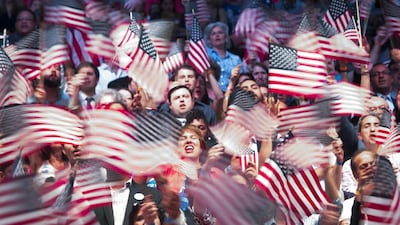Attendees wave American flags before Hillary Clinton, former Secretary of State and presumptive Democratic presidential nominee, speaks at a primary night event at the Brooklyn Navy Yard in the Brooklyn borough of New York. John Taggart / Bloomberg