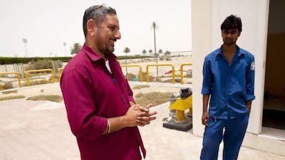 Parvender Singh, 50, left, speaks to Philip Sarwar, 25, who is a second generation worker for the Dubai Municipality in the Drainage and Irrigation Network System