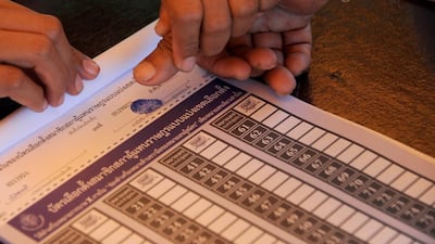 A Thai villager places his thumb pm a ballot paper prior to casting his vote at a polling station in Narathiwat province. AFP