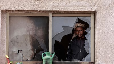 A Palestinian man at the window of a damaged house after an Israeli settler attack in the occupied West Bank. AFP